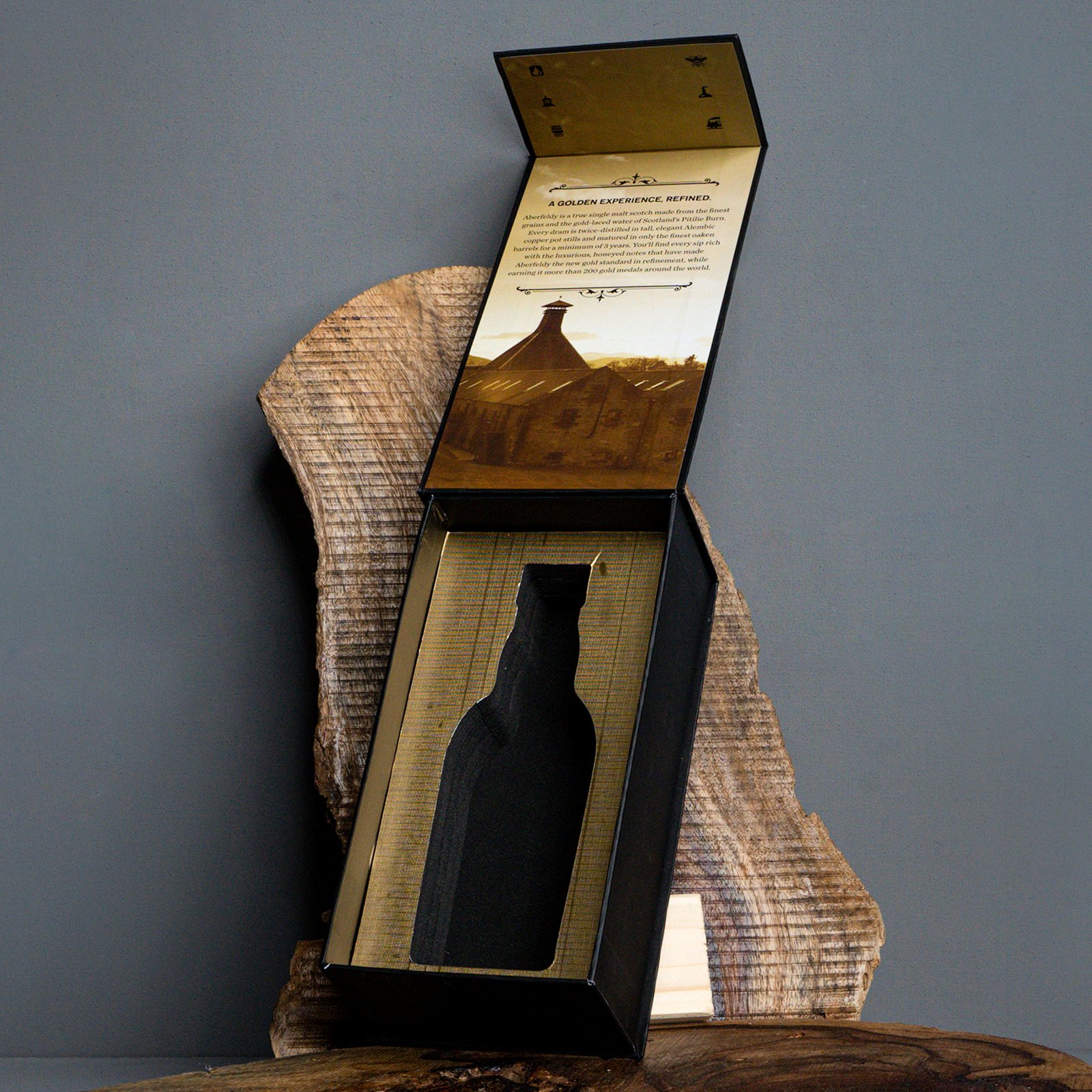 Custom flip-top rigid box packaging with magnetic closure featuring a bottle-shaped die-cut insert and inner gold foiled lid